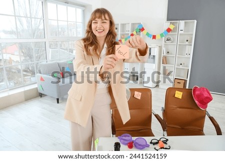 Business woman with sticky paper in office. April Fools' Day celebration