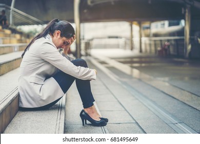 Business woman stressed from work while sitting outdoors on the stairs, concept work life balance, burn out syndrome, press from colleagues.