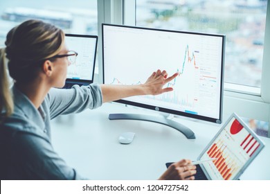 Business woman study financial market to calculate possible risks and profits.Female economist accounting money with statistics graphs pointing on screen of computer at desktop. Quotations on exchange - Shutterstock ID 1204727542