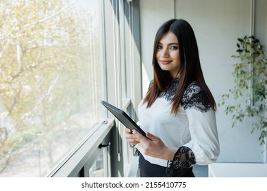 Business woman with a tablet working from an office Young handsome woman administrating a business