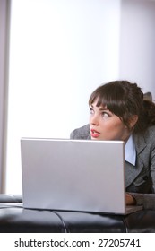 Mujer de negocios pensando en una oficina moderna con laptop