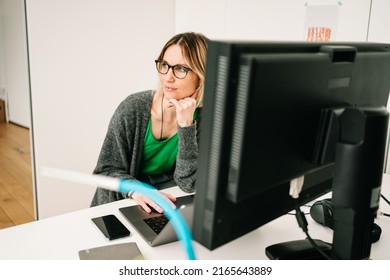 Business Woman Thinking In Office In Front Of Her Desk With A Computer