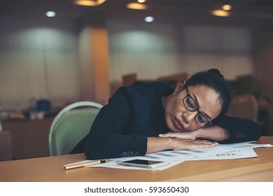 Business woman is tired and sleeps on the desk during her working time.