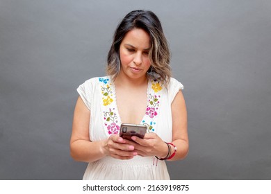 Business Woman In Traditional Mexican Dress Using Cell Phone