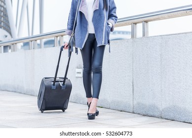 Business woman traveling with trolley. Women's legs, close-up