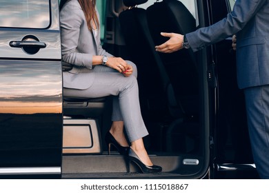 Business woman travelling in vip car transfer. Driver helping woman to get outside the car. Gentleman give a hand to the lady at the car - Shutterstock ID 1115018867
