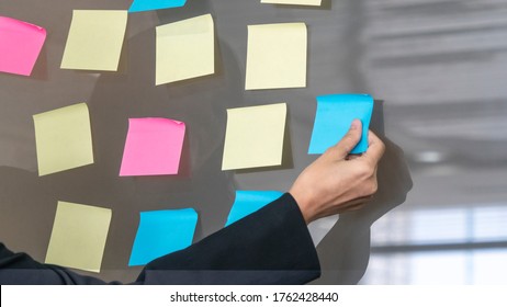 Business Woman Uses Paper Post Stick On Glass And Standing Front Of Glass War In Room With Nature Trees Background.