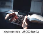 Business woman using calculator to calculate company finance, accounting with laptop computer on office table, budget management. Doing home finance, budgeting and tax calculation