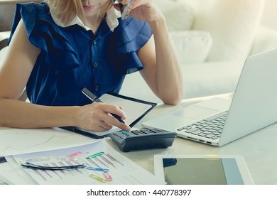 Business Woman Using A Calculator To Calculate The Numbers On His Desk In A Office.