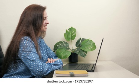 A Business Woman Using Computer Conducts Video Conference During Working Hours, Talks With Client At Workplace In Office. Happy Young Girl Sitting At Table, Doing Internet Work In Living Room At Home.