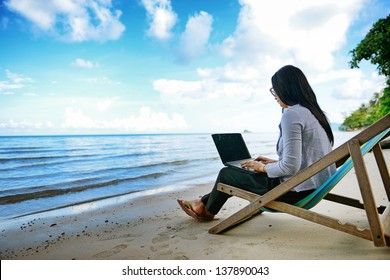 Business Woman Using A Laptop Beside The Beach