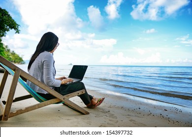 Business Woman Using A Laptop Beside The Beach