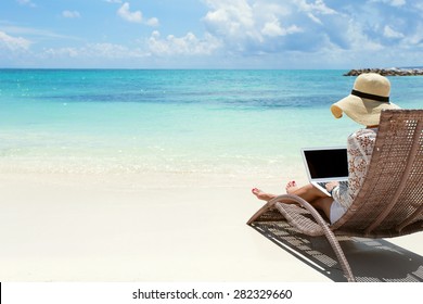 Business Woman Using Laptop Computer On The Beach