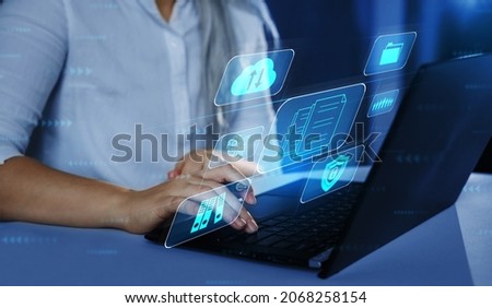 Business woman using a laptop with digital graph to document management. Software online documentation database and digital file storage system and file access concept.