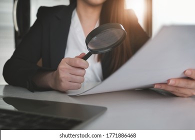 Business Woman Using Magnifying To Review Balance Sheet Annual. Audit And Check Integrity Before Investment Concept.