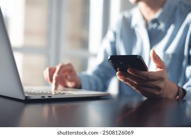 Business woman using mobile smart phone and online working on laptop computer, surfing the internet, searching the information at office. Female student online studying from home, e-learning