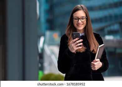 Business woman using phone and holding notes