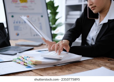Business woman using smartphone for contract customer on wooden desk in office, tax, accounting, statistics and analytic research concept - Shutterstock ID 2310775895