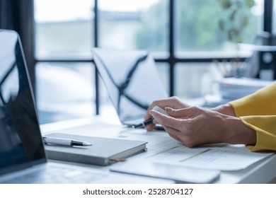 Business woman using smartwatch analyzing checking business data on financial documents, planning strategy analysis report, thinking and looking for new opportunities - Powered by Shutterstock