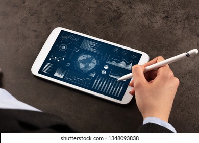 Business woman verifying reports on tablet with pencil in business suit