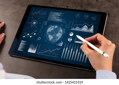 Business woman verifying reports on tablet with pencil in business suit