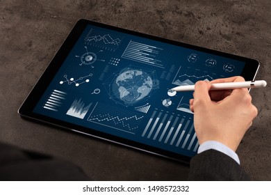 Business woman verifying reports on tablet with pencil in business suit
