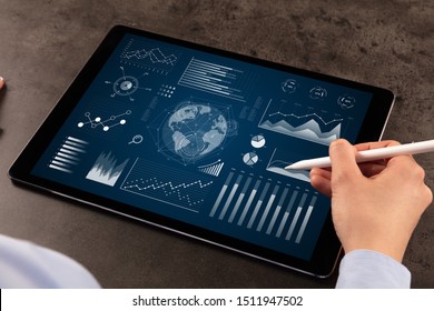 Business woman verifying reports on tablet with pencil in business suit