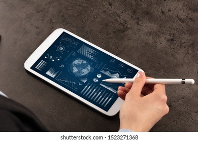 Business woman verifying reports on tablet with pencil in business suit