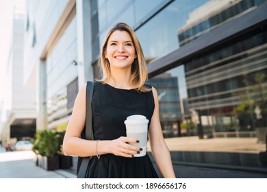 Business Woman Walking To Work While Drinking Coffee.