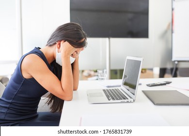 Business Woman Wearing Face Mask Because Of Covid-19 Sits With Burnout Due To Overload On Computer