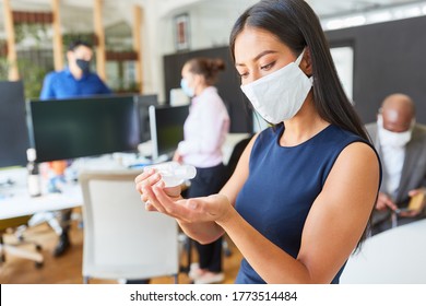 Business Woman Wearing Face Mask In The Office Disinfecting Hands Because Of Covid-19 And Corona Virus