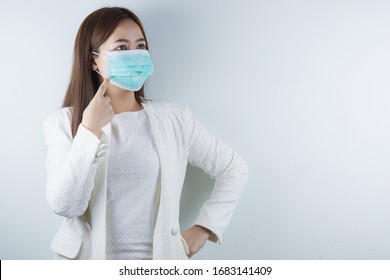 The business woman wearing protection face mask against coronavirus, PM 2.5 and cold, and her finger point on her mask. - Shutterstock ID 1683141409