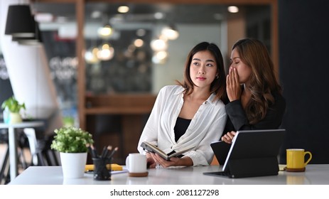 Business woman whispering something  in ear of her colleague. - Powered by Shutterstock