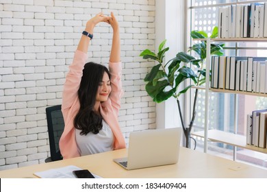 business woman work from home and stretching her body because feel tired after working on tablet computer, Lifestyle woman relax after working at home concept.