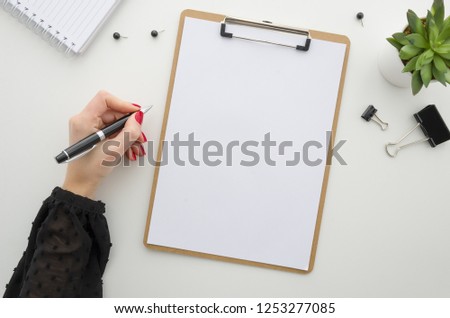 Business woman working with documents. Clipboard mockup template paperwork, financial reports,resume, brief, form, contract. Beautiful female hands in a black blouse with a red manicure holding a pen.