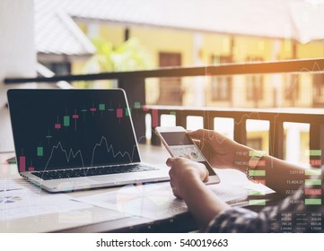 Business Woman Is Working With Mobile Phone And Computer With Stock Chart And Data Overlay