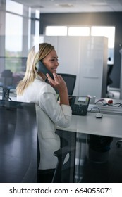 Business Woman Working In Office. Woman Talking On Landline Phone.