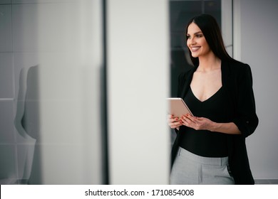 Business woman working at the office.Beautiful woman drinking coffee and using the phone.