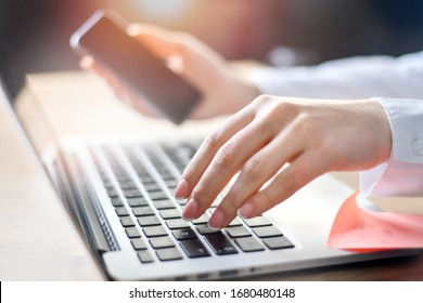 Business woman working on laptop computer on wooden desk as concept with social media success technology. Hands typing detail.