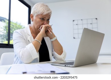 Business Woman Working On Laptop Computer In Modern Home Office.  Senior Woman Serious Working On Laptop. Serious Mature Older Adult Woman Watching On Laptop Working From Home.