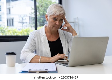 Business Woman Working On Laptop Computer In Modern Home Office.  Senior Woman Serious Working On Laptop. Serious Mature Older Adult Woman Watching On Laptop Working From Home.