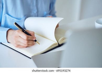 Business woman writing in a notebook                                - Shutterstock ID 695193274