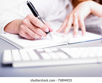 Business Woman Writing With Pen In Notepad