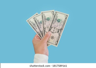 business woman's hand holding dollars isolated on blue background. 5 dollar bills - Shutterstock ID 1817589161