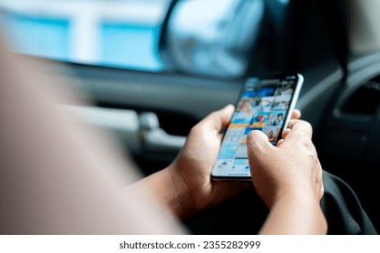 Business  Woman's hand using smartphone while sitting in car for entertainment during traffic jam or during a long trip, emailing, submitting work, online, communication,social media - Powered by Shutterstock