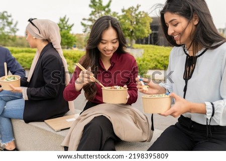 business women coworkers having breakfast outdoors