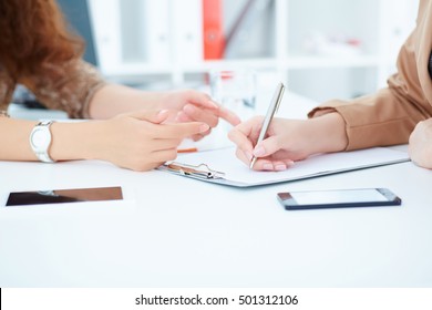 Business women or employee at workplace writing business ideas, plans or tasks at empty sheet of paper.