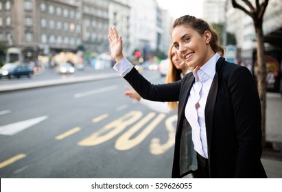 Business Women Hailing Taxi On Street