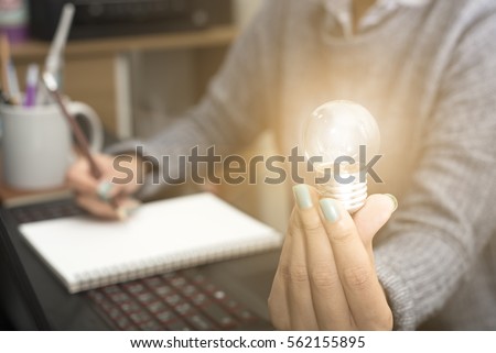 Business women hand holding light bulb, concept of new ideas with innovation and creativity.
