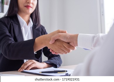 Business women and job seekers shake hands after agreeing to accept a job and approve it as an employee in the company. Or a joint venture agreement between the two businessmen